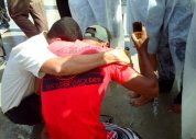 Jovem dobra os joelhos e volta para Jesus na areia da praia de Pajuçara